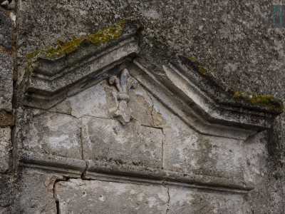 Le finestre del secondo piano, di cui una parzialmente murata, sono puntellate da assi di legno e sovrastate da dei timpani abbelliti da altri gigli